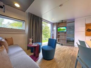 a living room with a couch and a blue chair at Tiny House, Neunburg vorm Wald in Neunburg vorm Wald