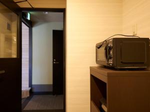 京都的住宿－若平安白川酒店　Waka Heian Shirakawa Hotel，坐在一个房间梳妆台上看电视