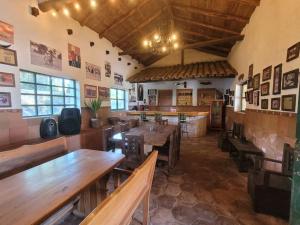 un restaurante con mesas de madera y bancos en una habitación en Hacienda San Mateo, en Cotacachi
