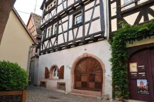 un edificio con una puerta de madera en una calle en Gite Chez Marianne, en Riquewihr