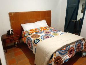a bed with a colorful quilt in a bedroom at Hacienda San Mateo in Cotacachi