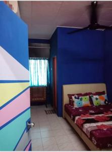 ein Schlafzimmer mit einer blauen Wand und einem Bett in der Unterkunft Blue Homestay Teluk Kemang Port Dickson in Port Dickson