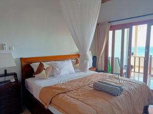 a bedroom with a bed with a view of the ocean at Raweg Studio in Amed