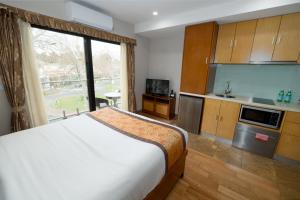 1 dormitorio con 1 cama y cocina con ventana en Melrose Apartments en Melbourne