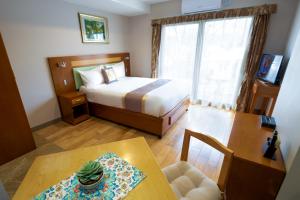 a bedroom with a bed and a table and a dining room at Melrose Apartments in Melbourne