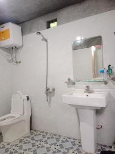 uma casa de banho com um lavatório, um WC e um espelho. em homestay phô núi suôi giang em Yên Bái