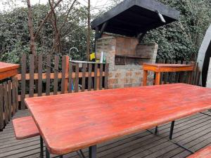 una mesa de picnic de madera en una terraza con chimenea en Casa Rural Curicó - Apartamentos, en Curicó