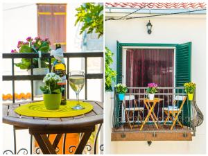 a table with a glass of wine and flowers on a balcony at Apartments Cambi in Kaštela
