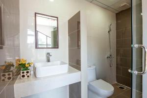 a bathroom with a sink and a toilet and a mirror at Thiên Trang Hotel Đà Lạt in Da Lat