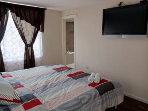 1 dormitorio con 1 cama y TV de pantalla plana en Departamento Doble con Jacuzzi en Cuenca