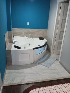 y baño con bañera y pared azul. en Departamento Doble con Jacuzzi en Cuenca
