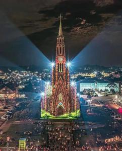 eine große Kirche mit einem Uhrturm in der Nacht in der Unterkunft Casa em Canela RS in Canela