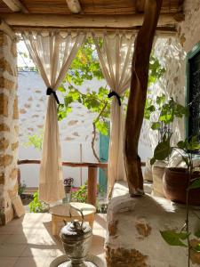 a porch with curtains and a view of the ocean at Berber Beldi Camp in Imsouane +38 photos