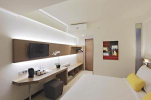 a hotel room with a bed and a desk at Euphoria Hotel in Legian