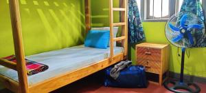 a bedroom with two bunk beds and a fan at Hostel Kiliwood in Moshi