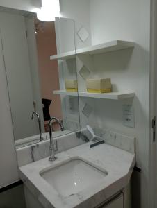 uma casa de banho com um lavatório e um espelho em Studio 811 em Marília