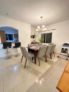 Villa Vaoli في بلايا ديل كارمن: غرفة طعام مع طاولة وكراسي خشبية