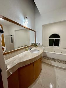 Villa Vaoli في بلايا ديل كارمن: حمام مع حوض ومرآة كبيرة