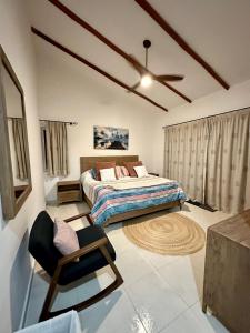 1 dormitorio con 1 cama y 1 silla en Villa Vaoli, en Playa del Carmen