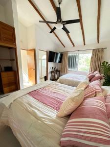 Villa Vaoli في بلايا ديل كارمن: غرفة نوم بسريرين ومروحة سقف
