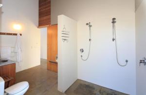 een badkamer met een douche, een toilet en een wastafel bij The Pah in Onetangi