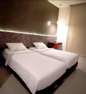 TemulusにあるCendana CoLiving Solo Baruのベッド2台が隣同士に設置された部屋です。