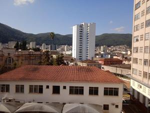 a white building with a red roof in a city at ap 34 centro in Poços de Caldas