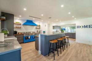 uma cozinha com armários azuis e uma ilha azul com bancos em Life is Blue em Fort Lauderdale