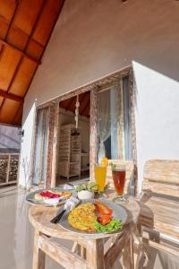 einen Tisch mit einem Teller Essen darüber in der Unterkunft Cassava Penida Cottage in Nusa Penida