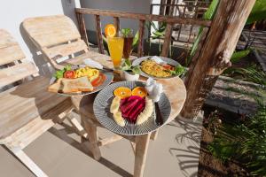 two plates of food on a table on a balcony at Cassava Penida Cottage in Nusa Penida