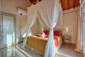 ein Schlafzimmer mit einem Himmelbett in der Unterkunft Cassava Penida Cottage in Nusa Penida