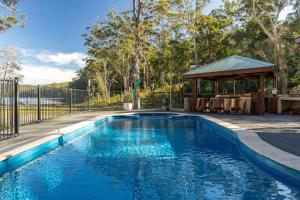 a swimming pool in a yard with a gazebo at Tambo Lindo in Smiths Lake