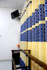 Habitación con cortina azul y amarilla en Meegahapokuna Resort, en Anuradhapura
