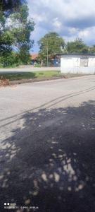 uma rua vazia com uma sombra de árvore na estrada em FIZWAN HOMESTAY em Kuantan