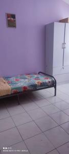 uma cama num quarto com piso em azulejo em FIZWAN HOMESTAY em Kuantan