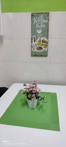 um vaso de flores sobre uma mesa com um sinal em FIZWAN HOMESTAY em Kuantan