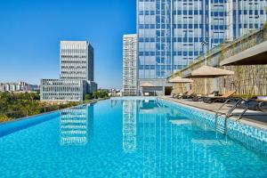 una gran piscina con sillas y edificios en DoubleTree by Hilton Guangzhou Zengcheng, en Guangzhou