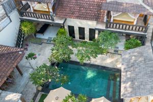 een uitzicht over een zwembad met bomen en parasols bij Rumah Singa - Holistic Healing Retreat in Gili Air