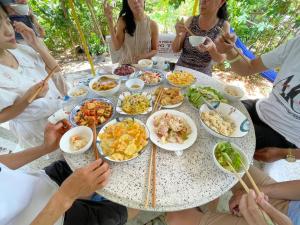a group of people sitting around a table with food at Đức Lưu Quang Hotel Bình Thuận in Tuy Phong
