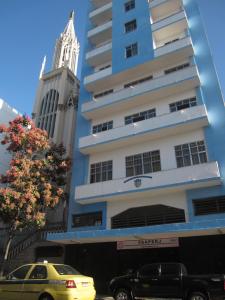 a tall building with cars parked in front of it at Lapa Chêca Guest House in Rio de Janeiro