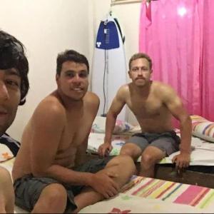 Due uomini seduti su un letto in una camera da letto di Jimmy Losmen Nias a Lagudri