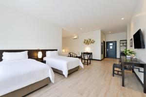 una camera d'albergo con 2 letti e una scrivania di Oldthaiheng Hotel a Bangkok