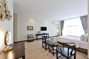 a living room with a bed and a table at Oldthaiheng Hotel in Bangkok