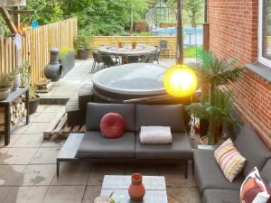 a patio with a couch and a table and a tub at 5 star holiday home in Grindsted-By Traum in Grindsted
