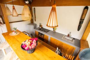 een keuken met een houten tafel met een kom bloemen erop bij Rumah Singa - Holistic Healing Retreat in Gili Air