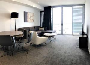 a living room with a couch and a table and chairs at Serain Residences on 88 Archer Chatswood in Sydney