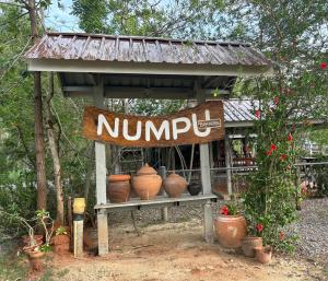 a sign for a bunch of pots on a bench at Numpu Baandin in Sam Roi Yot