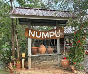 Ein Nimp-Schild auf einem Stand mit Töpfen drauf. in der Unterkunft Numpu Baandin in Sam Roi Yot