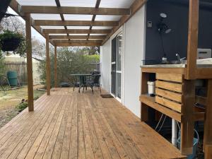 a wooden patio with a table and a wooden pergola at Self Contained Cabin in Nildottie