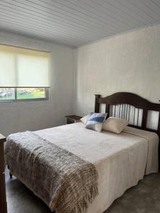 a bedroom with a large bed with pillows on it at Villa Serrana Cabaña Tata Ruben y Olga 2dormitorios in Villa Serrana +26 photos
